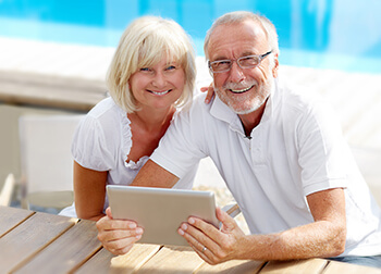 Older Woman and Man Reading a Tablet