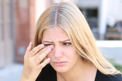 woman rubbing her eyes