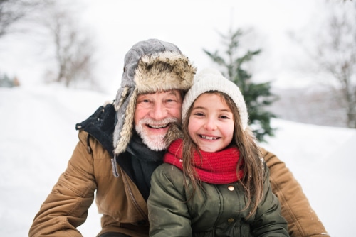 Grandfather And Small Girl In Snow On A Winter Day