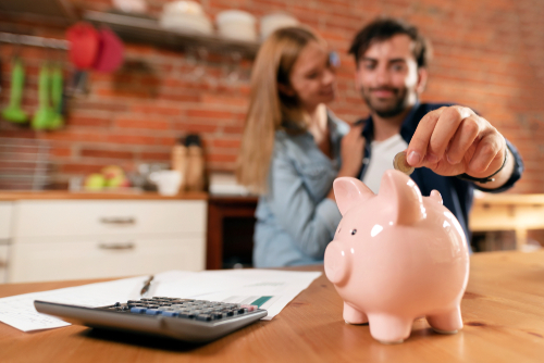 Couple putting change in a piggy bank