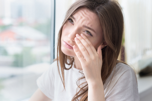 woman wiping eyes from dry eye 