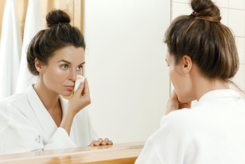 Young woman putting on makeup