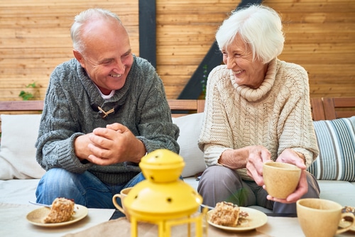 An elderly couple smile at each other