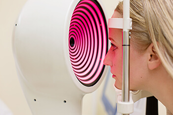 Woman having her eyes tested via visual field testing